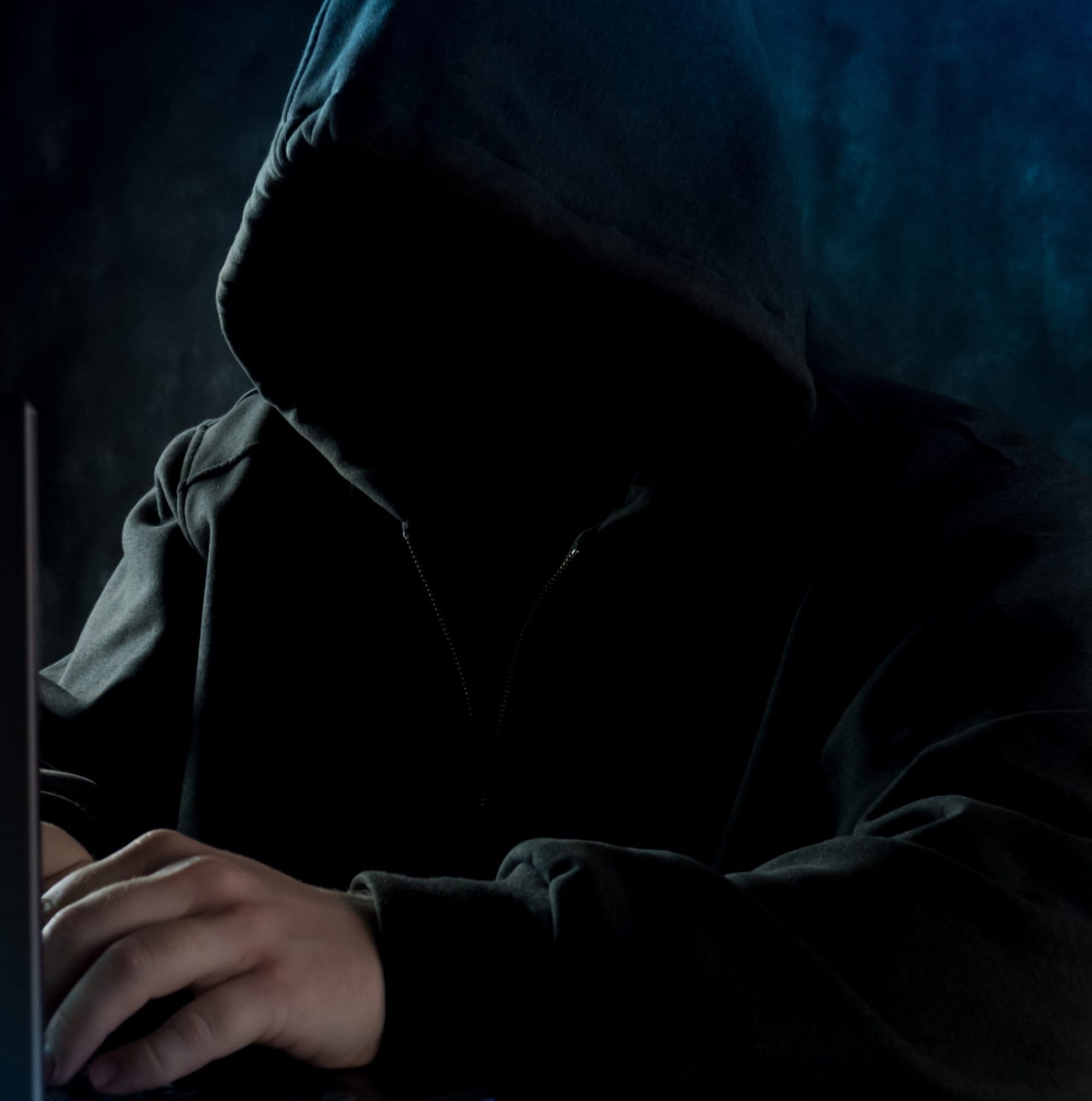 a man in a hoodie using a laptop computer